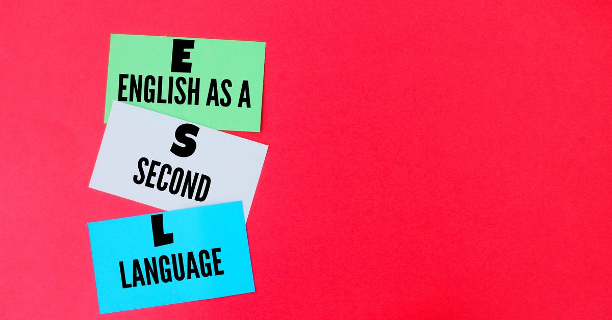 Green, white, and blue pieces of paper with the words "English as a second language" written across them on a red background.